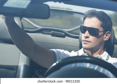 Front View Of A Young Man Driving His Convertible Car