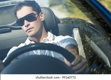 Front View Of A Young Man Driving His Convertible Car