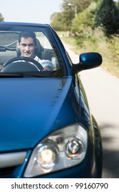 Front View Of A Young Man Driving His Convertible Car
