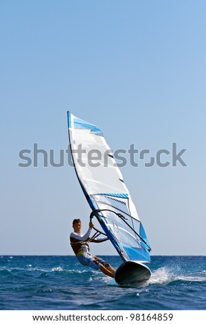 Front view of young man surfing the wind on summer day