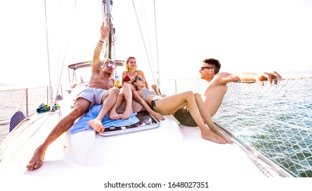 Front View Of Young Millennial Friends Chilling On Sailboat At Sea Ocean Trip - Guys And Girls Having Summer Fun Together At Sail Boat Party Day - Luxury Excursion Concept On Bright Contrast Filter