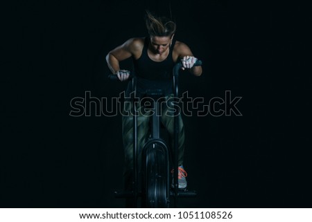 Front view of a young sporty woman doing calorie assault exercise on a fitness routine at the box gym
