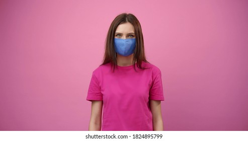 Front View Of Young Woman Wearing Facemask Looking At Camera, Isolated Pink Background