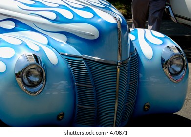 Front of vintage car, white with blue flames paint job