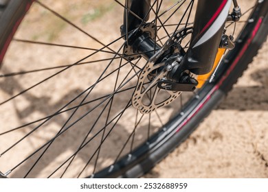 Front wheel of a bicycle, highlighting the disc brake system. Disc brakes offer excellent braking performance, especially in wet or muddy conditions. Spokes and rim. - Powered by Shutterstock