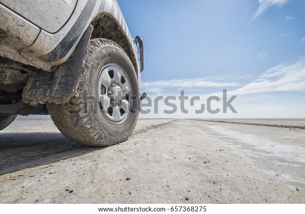 front wheel of a four by four car in\
Kalahari desert, concept and background  for driving off road,\
Makgadikgadi Pans National Park, Botswana,\
Africa