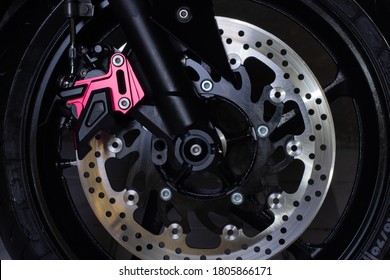 The Front Wheel Of A Motorcycle On A Dark Background. Close-up Disc Brakes And Spokes.