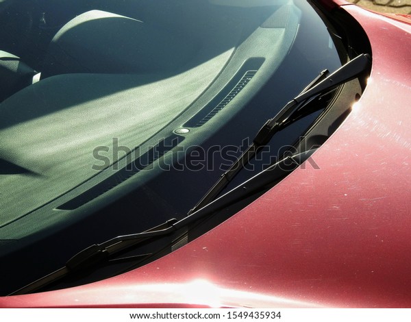 Front\
windshield wiper blades mounted on a red\
car