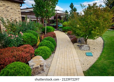 Front yard, landscape design with multicolored shrubs intersecting with bright green lawns behind the house is a modern, garden care service, green grass with a beautiful yard for the background.