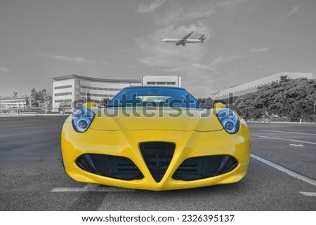A front of a yellow Italian Sport car and passenger airplane landing in the background 