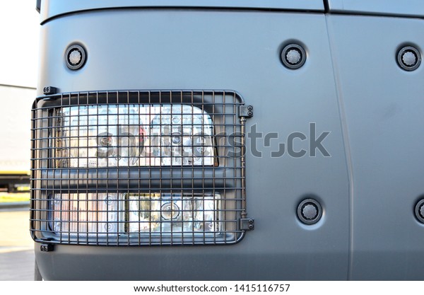 Frontal lighting products for on-highway vehicles,\
which includes integrated daytime running lights and beam patterns.\
Bi-Xenon and halogen headlamp of a modern truck, background texture\
- Image