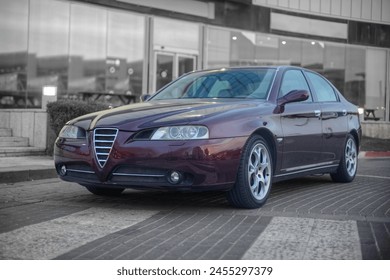 Frontal photo of a classic Italian car  with soft background of a commercial facade 