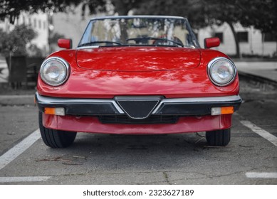 A frontal photo of an red Italian roadster car 