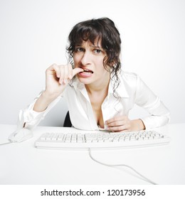 Frontal Portrait Of A Doubtful Woman Nail Biting At Her Office Desk