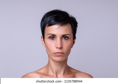 Frontal Portrait Of A Woman In Short Darker Hair Over Neutral Background