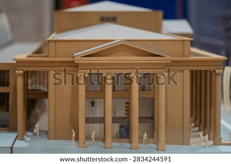 Frontal view of an architectural model of a classical building with a columned portico, a symmetric facade and a triangular pediment above the entrance, great for architecture blogs