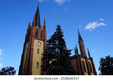 Frontal view of the of the facade of the landmark historic Heilig Geist church of Werder, Havel, Brandenburg, Germany, with its famous Gothic church towers under a clear blue sky. - Powered by Shutterstock