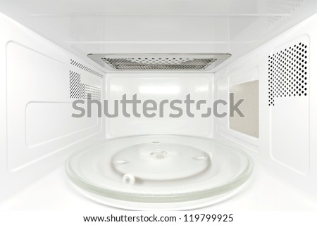 Frontal view inside white, empty clean microwave oven interior