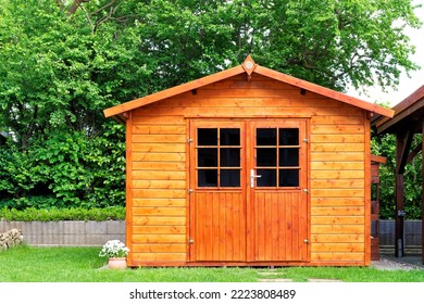 Frontal view of wooden garden shed glased in teak color