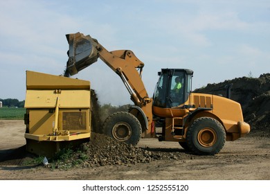 Frontend Loader Filling An Earth Crusher With Dirt