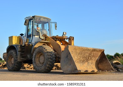Front-end loader working on construction site during the renovation of the road. 
