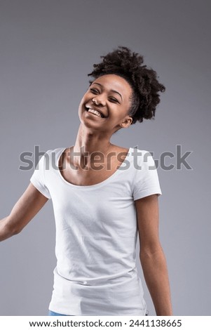 The front-facing portrait showcases a gleeful woman, her joyful energy matching her untamed, curly hairstyle