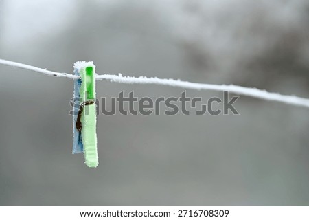 Frost on plastic clothes peg left on a washing line in winter