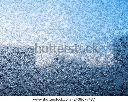frost on window glass of city apartment on cold winter evening