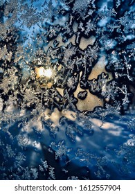 Frost on a window with the sun setting.