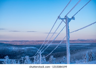 Frost And Snow Covered Power Lines During Very Cold Winter Against Sky In Finland