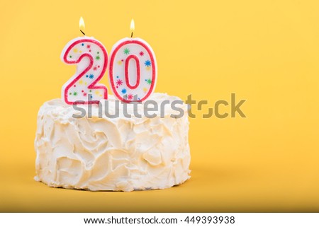 Frosted cake with the number 20 lighted candles