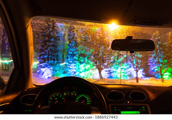 frosted car glass. snow covered car\
windshield. view from inside the car on the night\
city