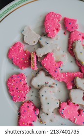 Frosted Circus Animal Cookie Pink And White Sprinkled Animal Crackers On White Plate With Green Greek Key