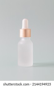 Frosted glass bottle with dropper pipette with serum or essential oil on a blue background. Skincare cosmetic Beauty concept for face body care. Place for text.
