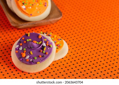 Frosted Icing Sugar Cookies On Black And Orange Polkadot Table