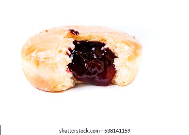 A frosted jelly filled donut with a bite out of it isolated on a white background