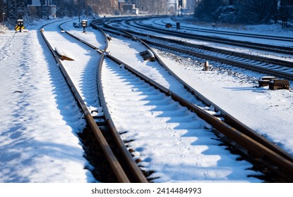 Frosted railway tracks with switches, rails, thresholds and screws covered with snow on a sunny winter day near Letmathe station. Railroad infrastructure on german main line from Hagen to Siegen. - Powered by Shutterstock