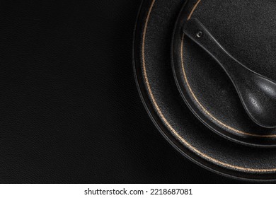 Frosted spoon on a ceramic dinner plate. The background is black leather. Luxurious, sumptuous fine tableware.Flat lay, top view, banner,horizontal photo - Shutterstock ID 2218687081