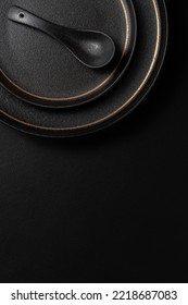 Frosted spoon on a ceramic dinner plate. The background is black leather. Luxurious, sumptuous fine tableware.Flat lay, top view, banner,vertical photo - Shutterstock ID 2218687083