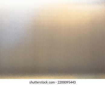 Frosted Wave glass vertical line pattern in the translucent effect of warm white light background. Slim and sleek line pattern glass close-up texture.