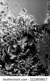 Frostwork pattern ice crystals on black background. Dark surface with abstract ice structure makes to overlay or add a frost effect. Frost on the glass, the effect of freezing