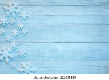 Frosty 3D Snowflakes on Rustic Wood Board Background with empty room or space for copy, text, your words.  Horizontal bright blue