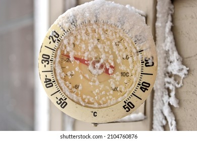 Frosty snow-capped outdoor Thermometer on a extremely cold, frigid winter's day
