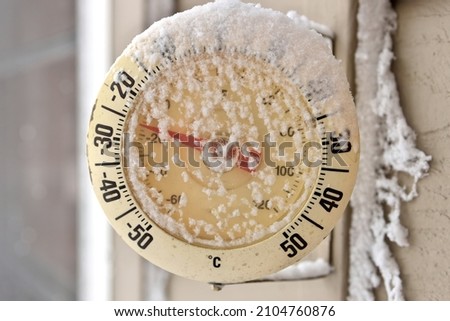 Frosty snow-capped outdoor Thermometer on a extremely cold, frigid winter's day