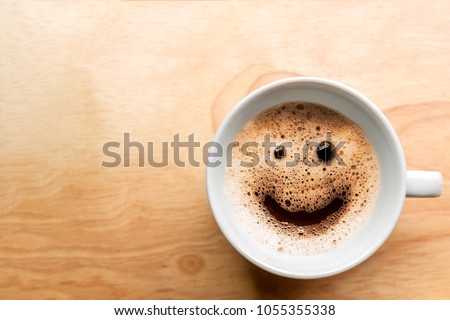 froth milk foam smiles in a cup of coffee in morning.