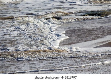 Frothy Indian Ocean waves breaking  onto the sandy shore  at Ocean Beach Bunbury Western Australia on a  sunny late morning  in winter are white and frothy.