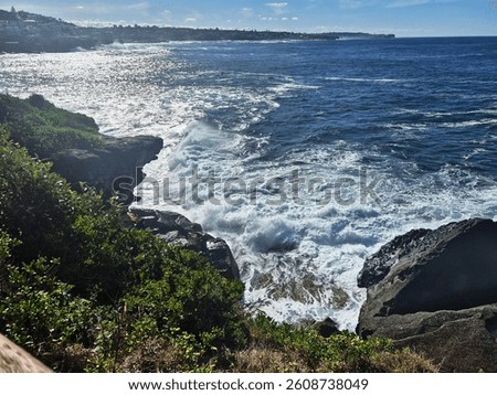 Frothy undercurrents swell in the foreground, as landforms stretch across the background