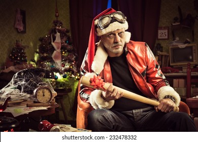 Frowning Bad Santa With Baseball Bat Gift Looking At Camera