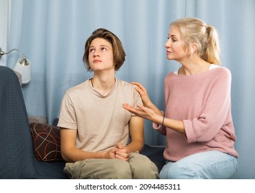 Frowning Teenager With Bored Expression Listening To Reprimanding From His Mother At Home..