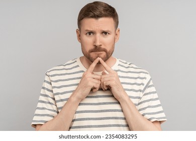 Frowning thoughtful nervous indecisive middle aged man feel hopeless guilty. Anxious doubting male with index fingers on chin think about difficult issues looking at camera isolated studio background